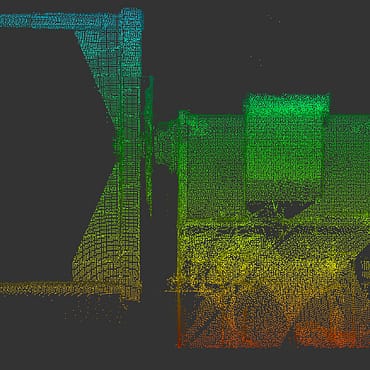 A detailed, multicolored 3D point cloud scan showing a side-elevation view of a large industrial tumbler in a pharmaceutical cleanroom.